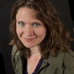 Lily Barger, Director of Computing Support Services at UC Riverside, wearing a olive green jacket smiling for headshot