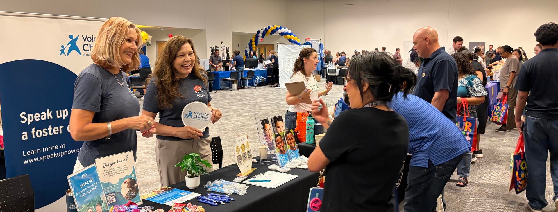 Community Partner Fair vendor chatting with event attendees.
