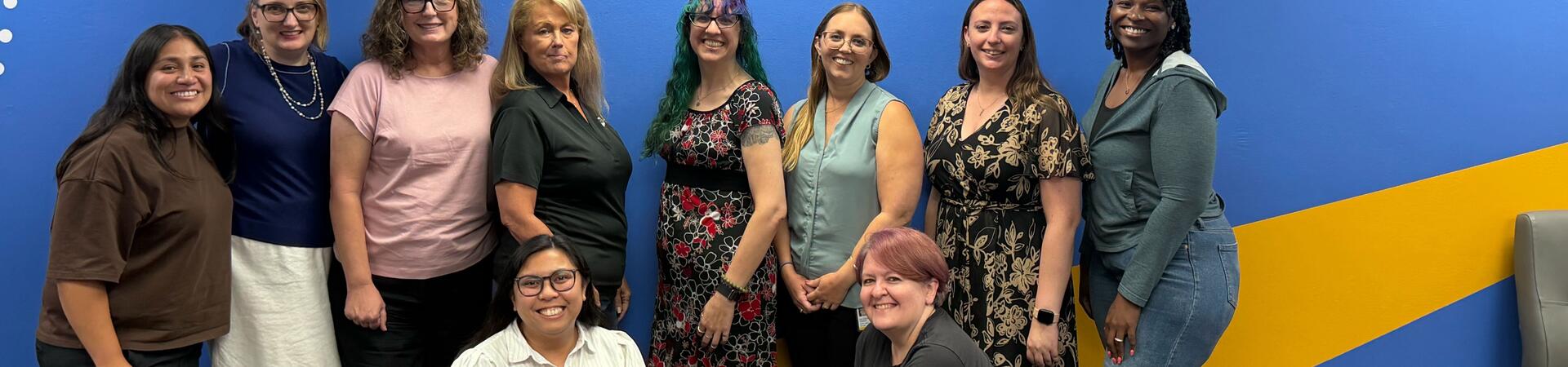 The 2026-2027 UCR Staff Assembly Executive Board members posing in front of the “Bold Hearts. Brilliant Minds.” wall mural.